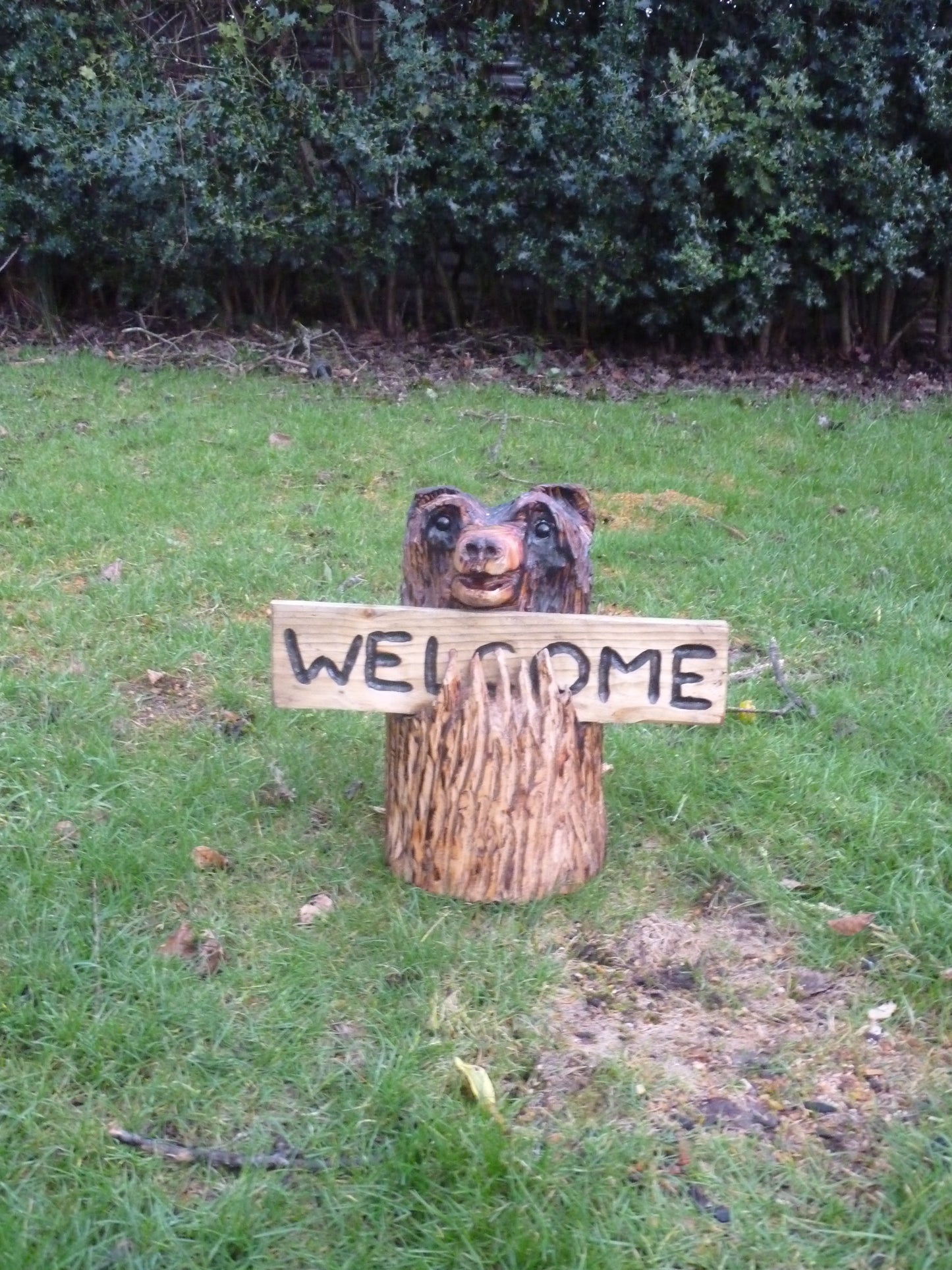 Chainsaw Carved Bear in a log with a welcome sign